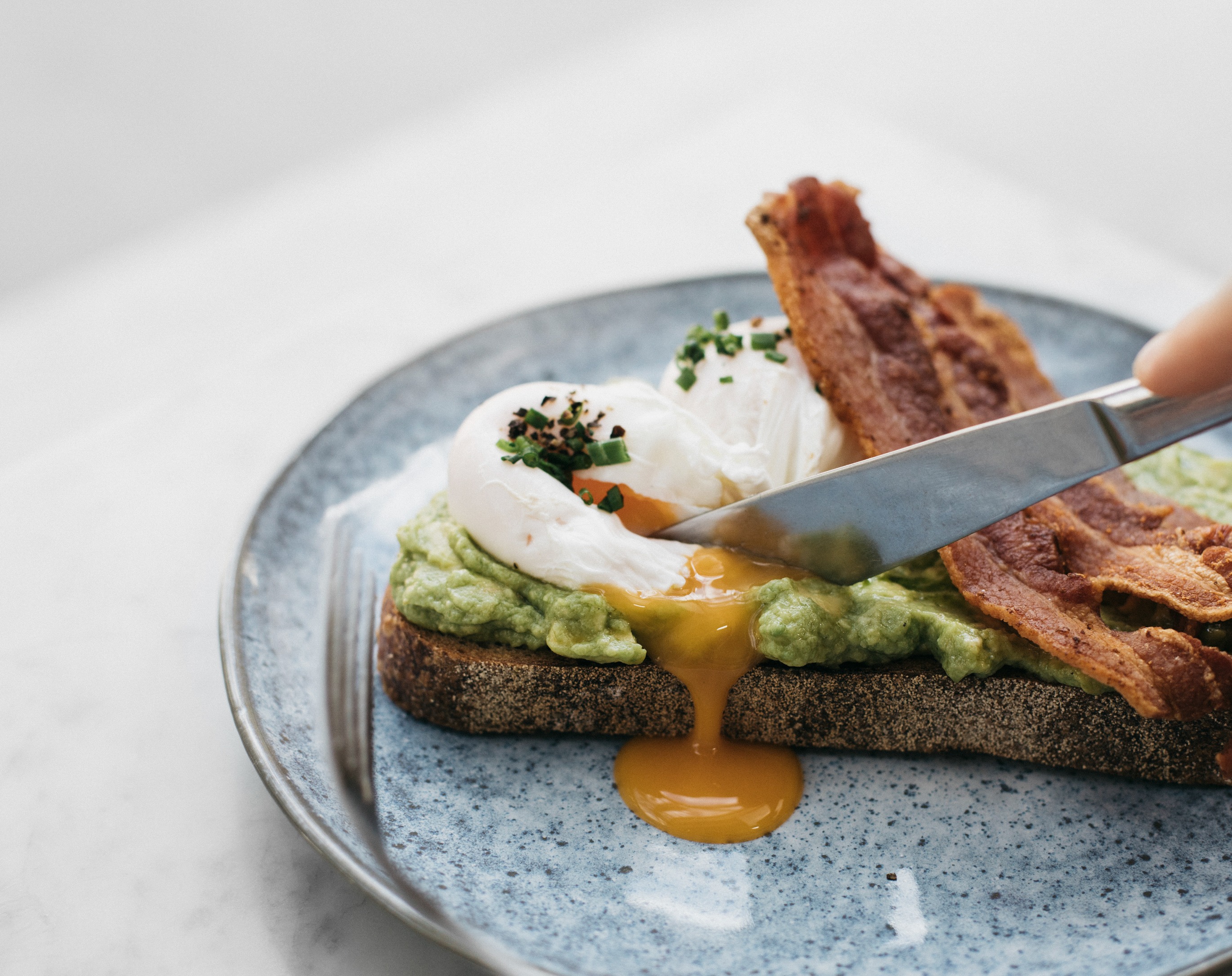 Poached egg, avocado toast and crispy bacon